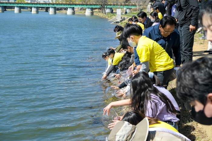 4.지난 13일 인안초등학교 학생들과 함께 어린 연어 5만 마리를 순천 동천에 방류했다.jpg